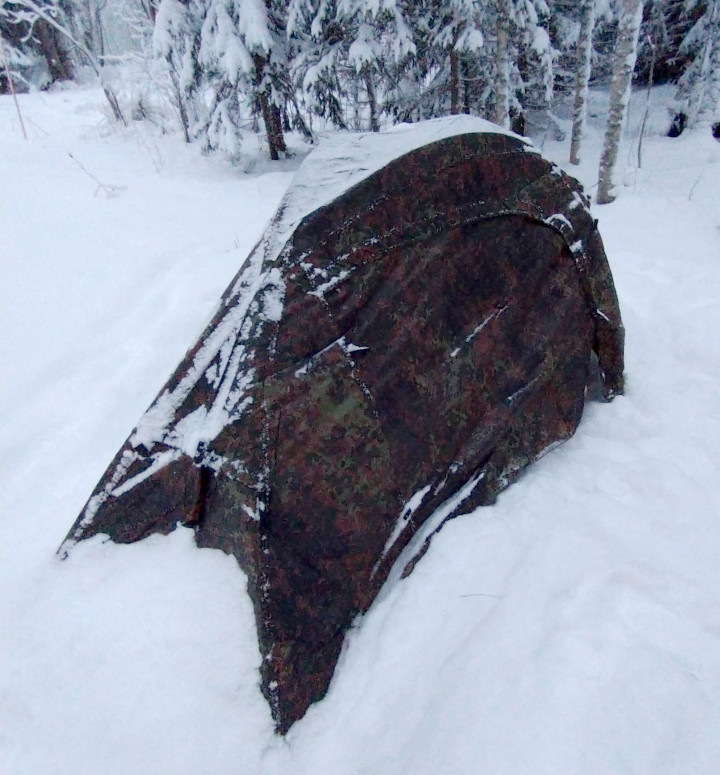 One person tent in the snow outside.